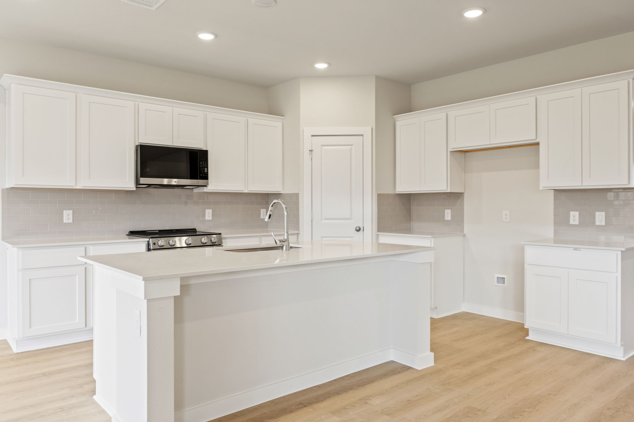 A kitchen with white cabinets.
