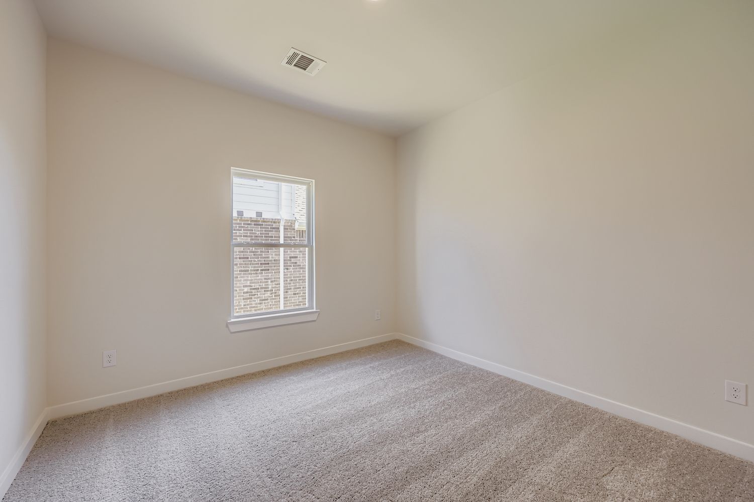 A room with a carpet and a window.