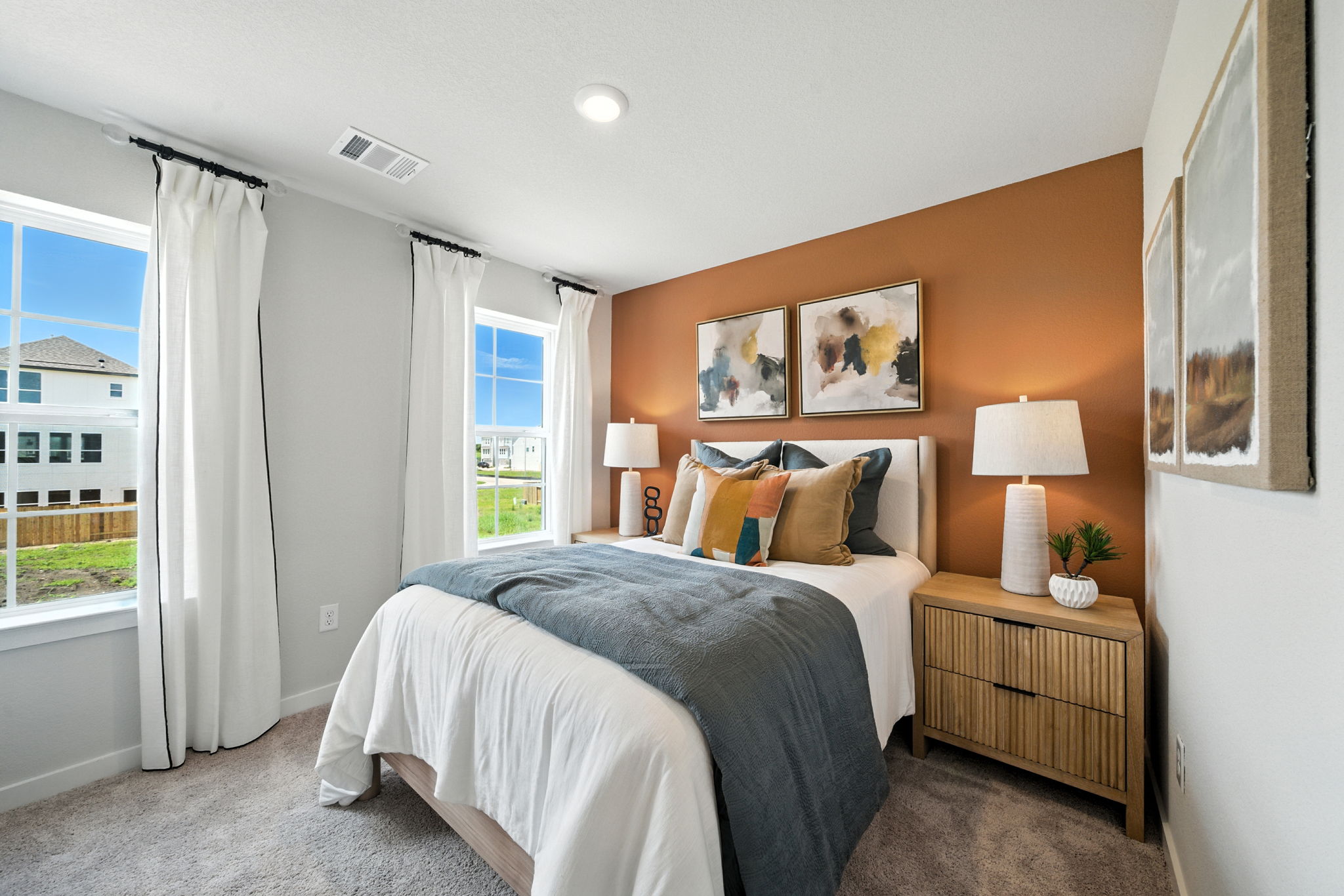 A bedroom with a bed and lamps.