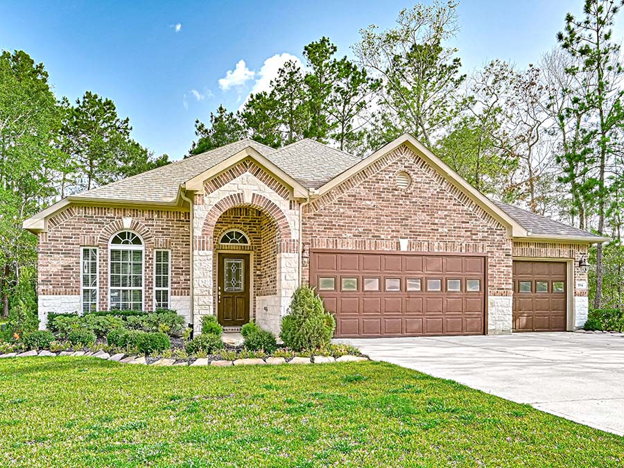A brick house with a large front yard.