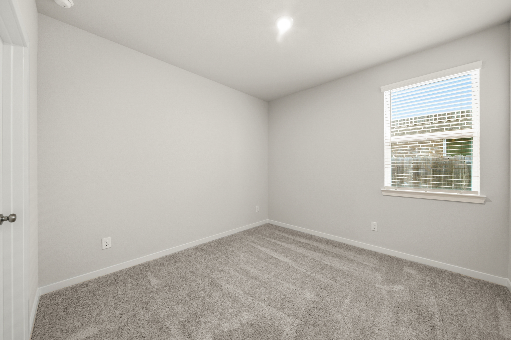 A room with a window and a carpet.