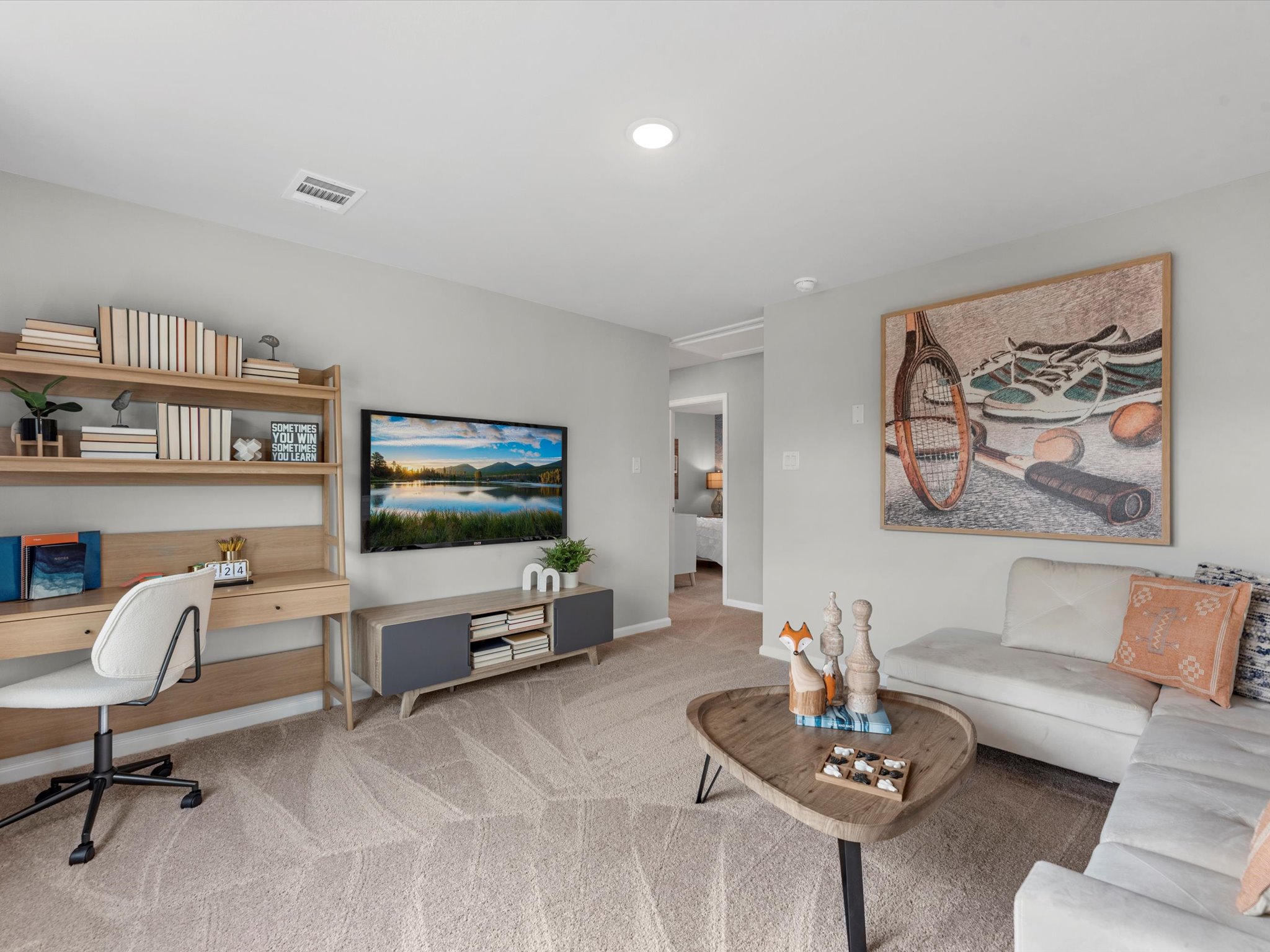 A living room with a desk and a couch.
