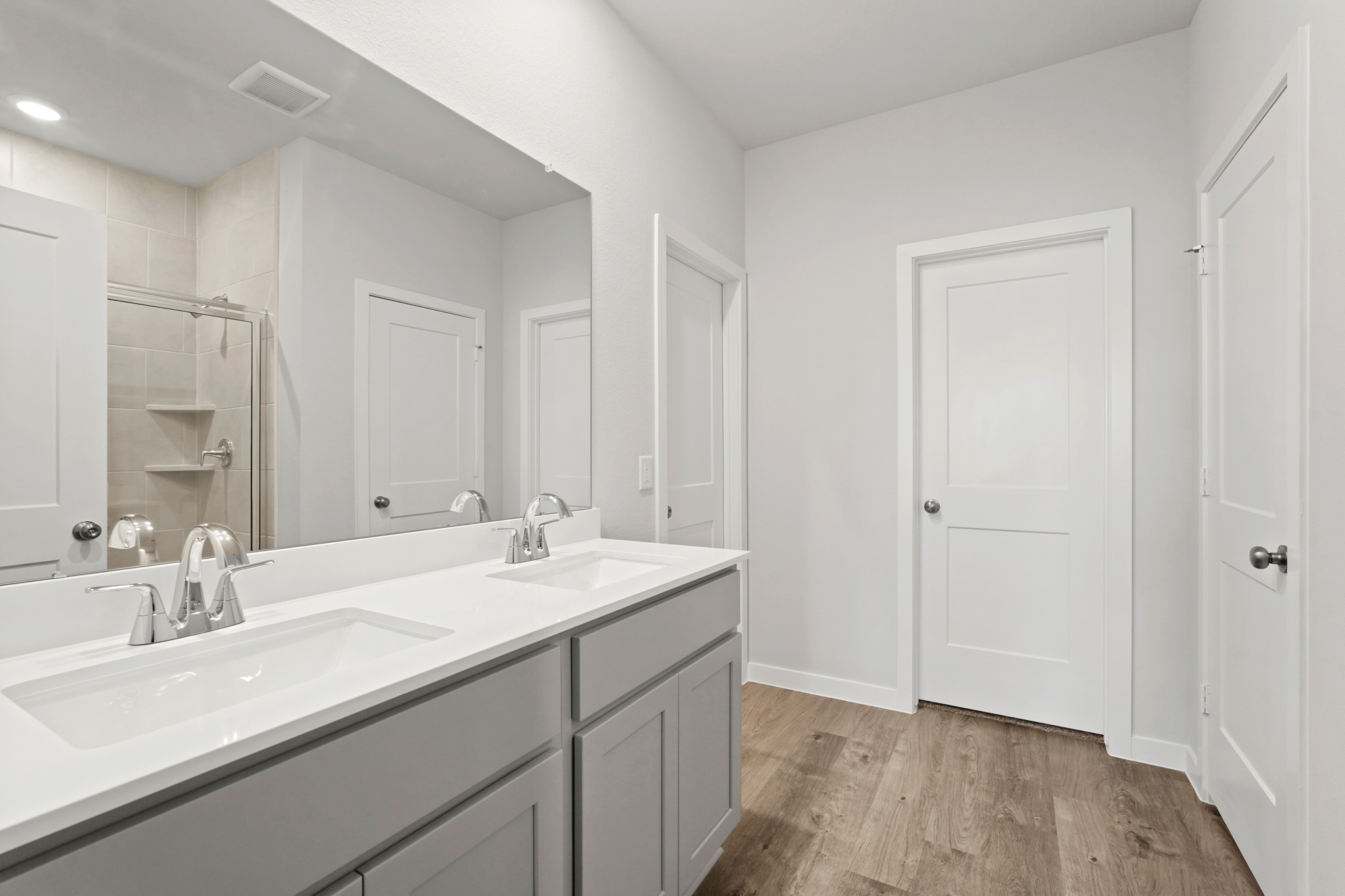 A bathroom with white cabinets.