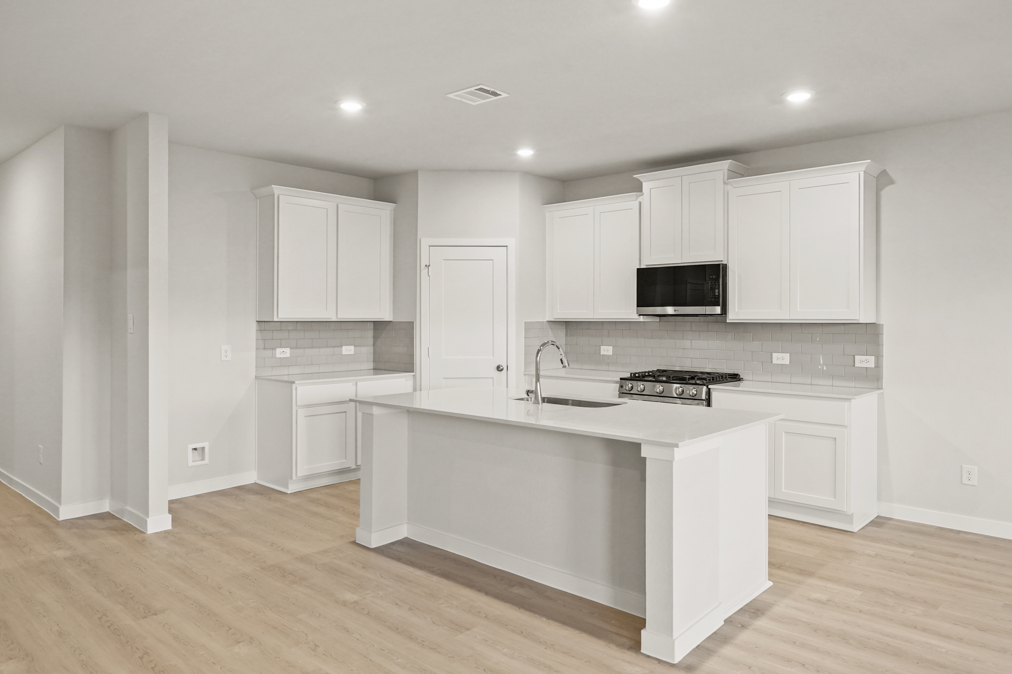 A kitchen with white cabinets.