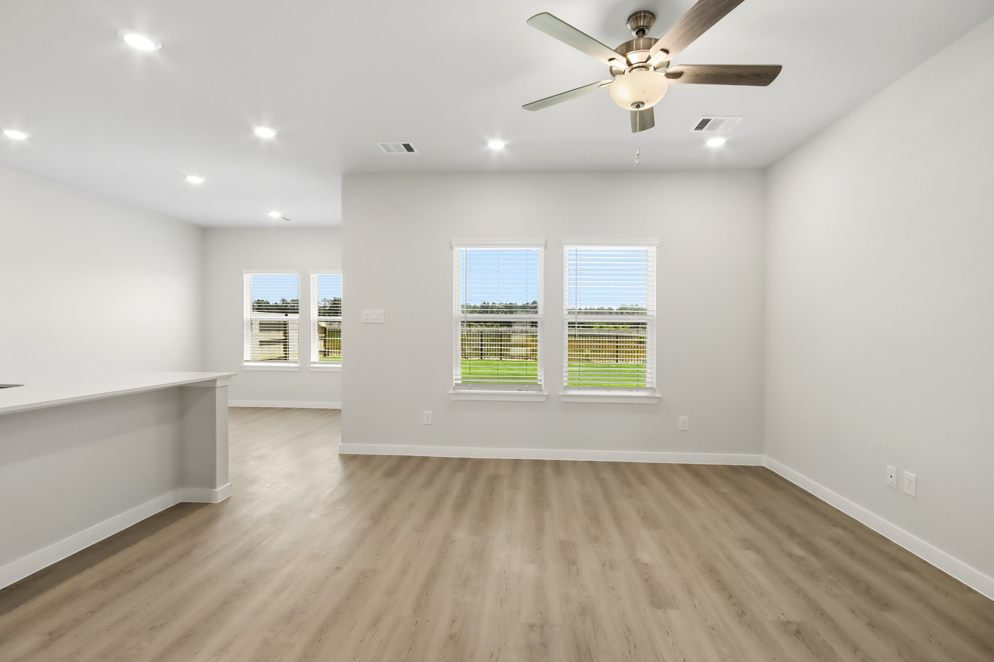 A room with a wood floor and a ceiling fan.