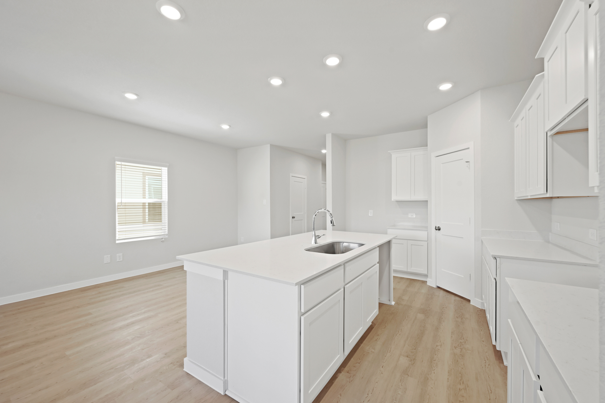 A kitchen with white cabinets.