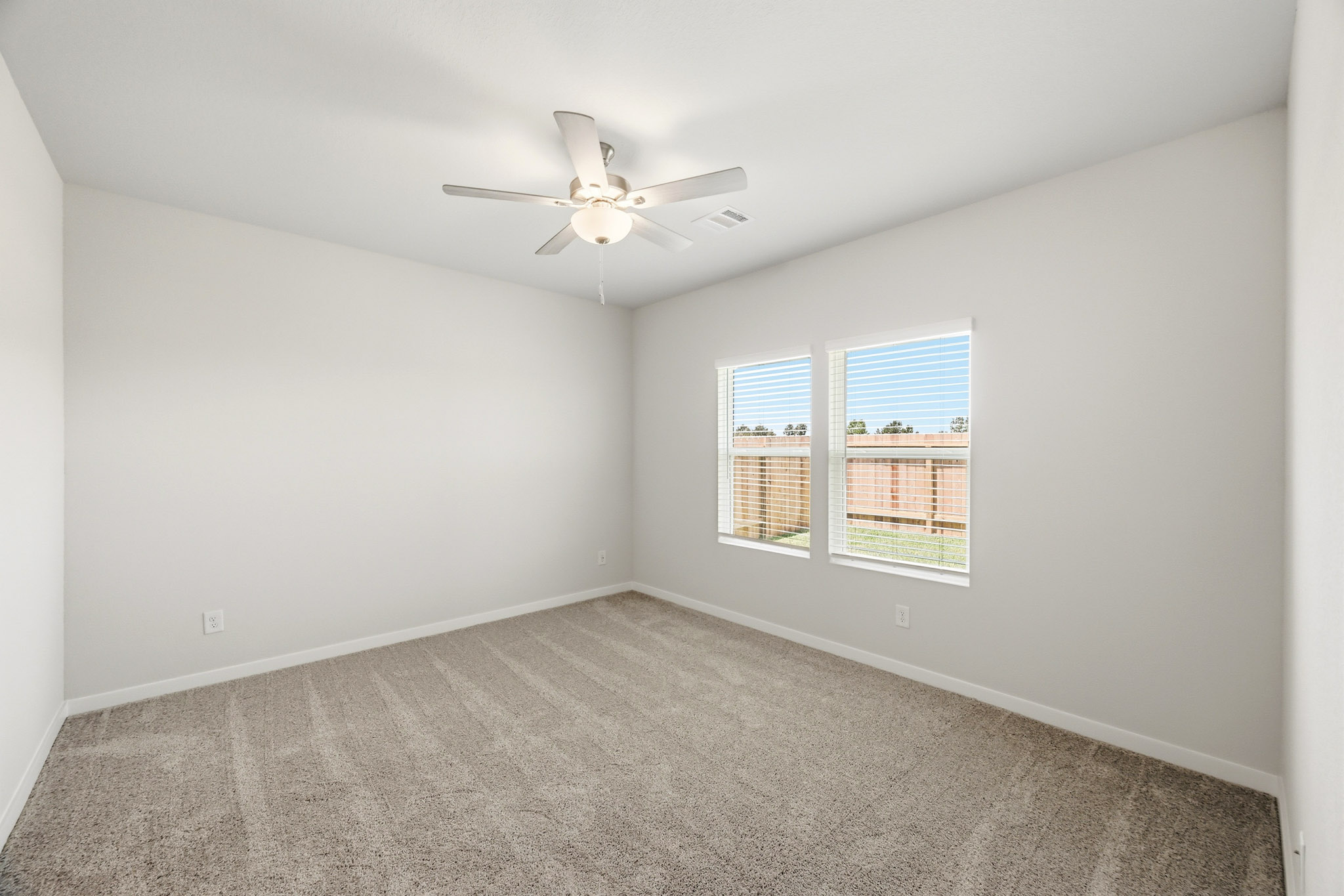 A room with a ceiling fan and a window.