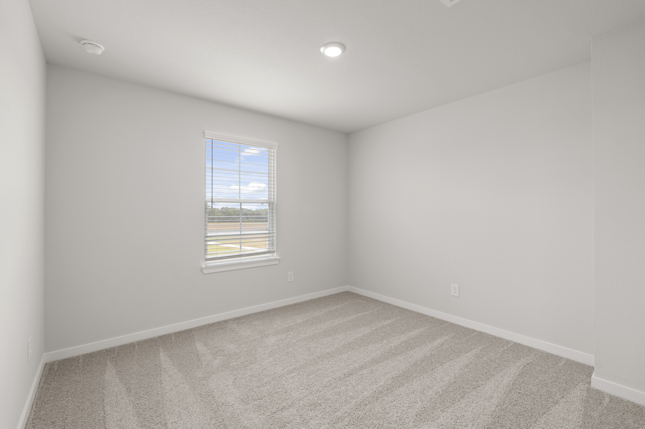 A room with a window and a carpet.