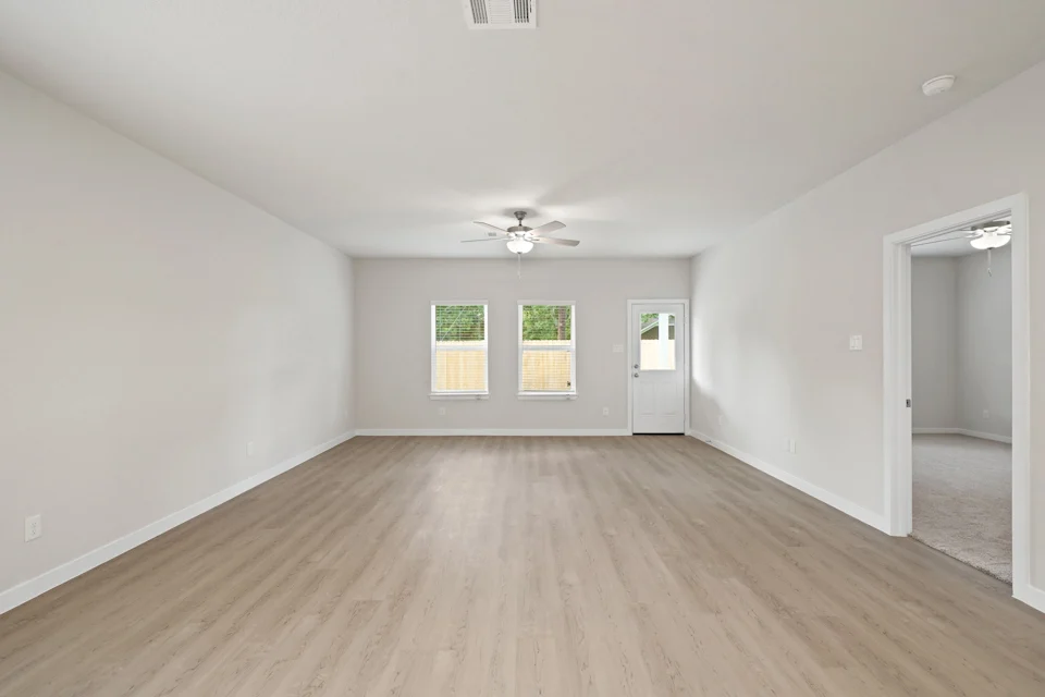 A room with a wood floor and a ceiling fan.