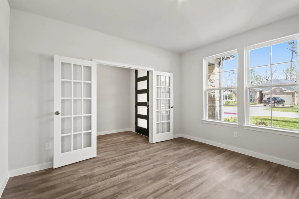 A room with a wood floor and white walls.