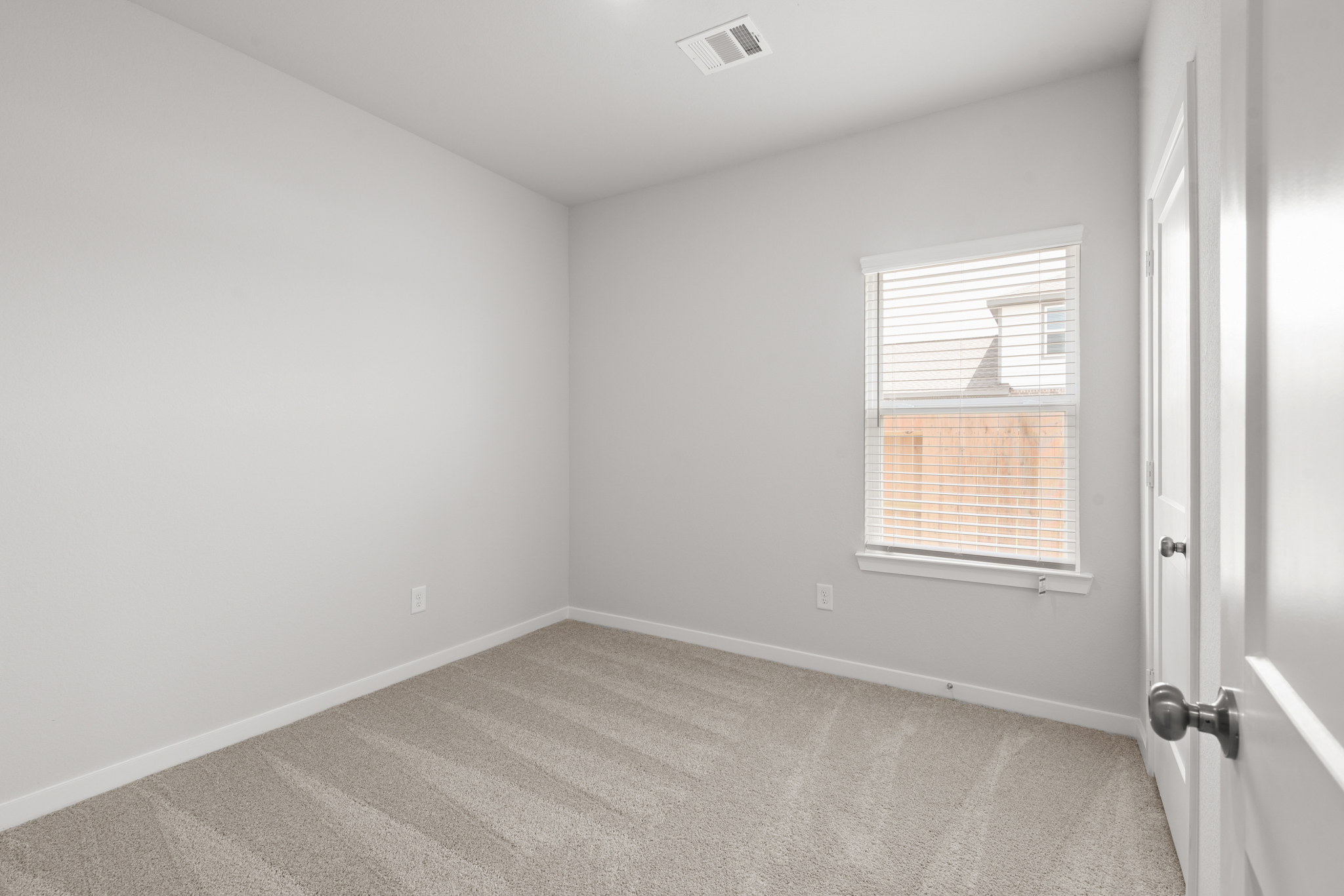 A room with a window and a carpet.