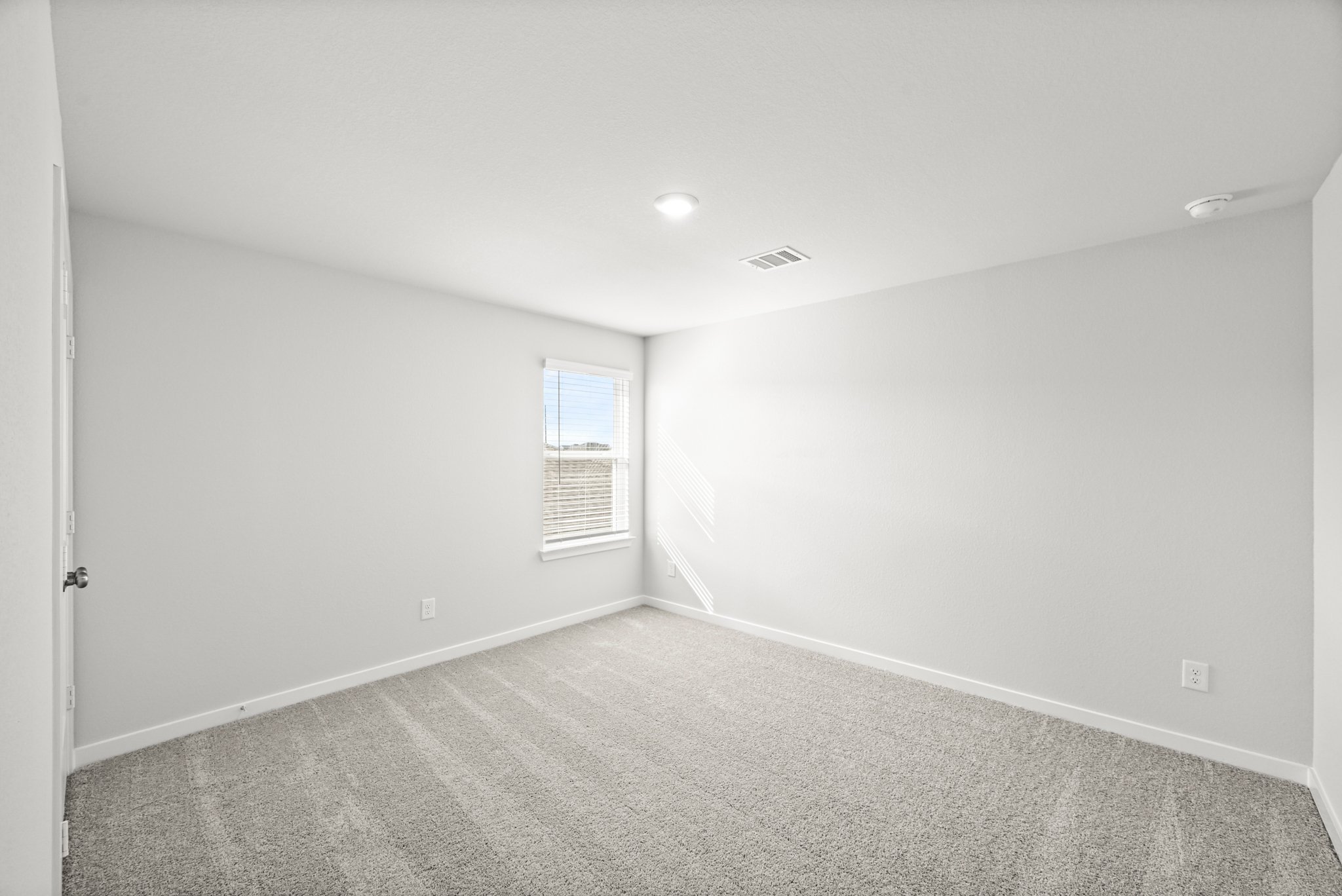 A room with a carpet and a window.