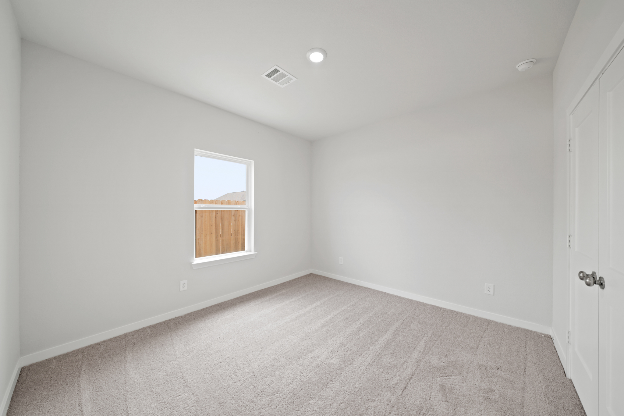 A room with a window and a carpet.