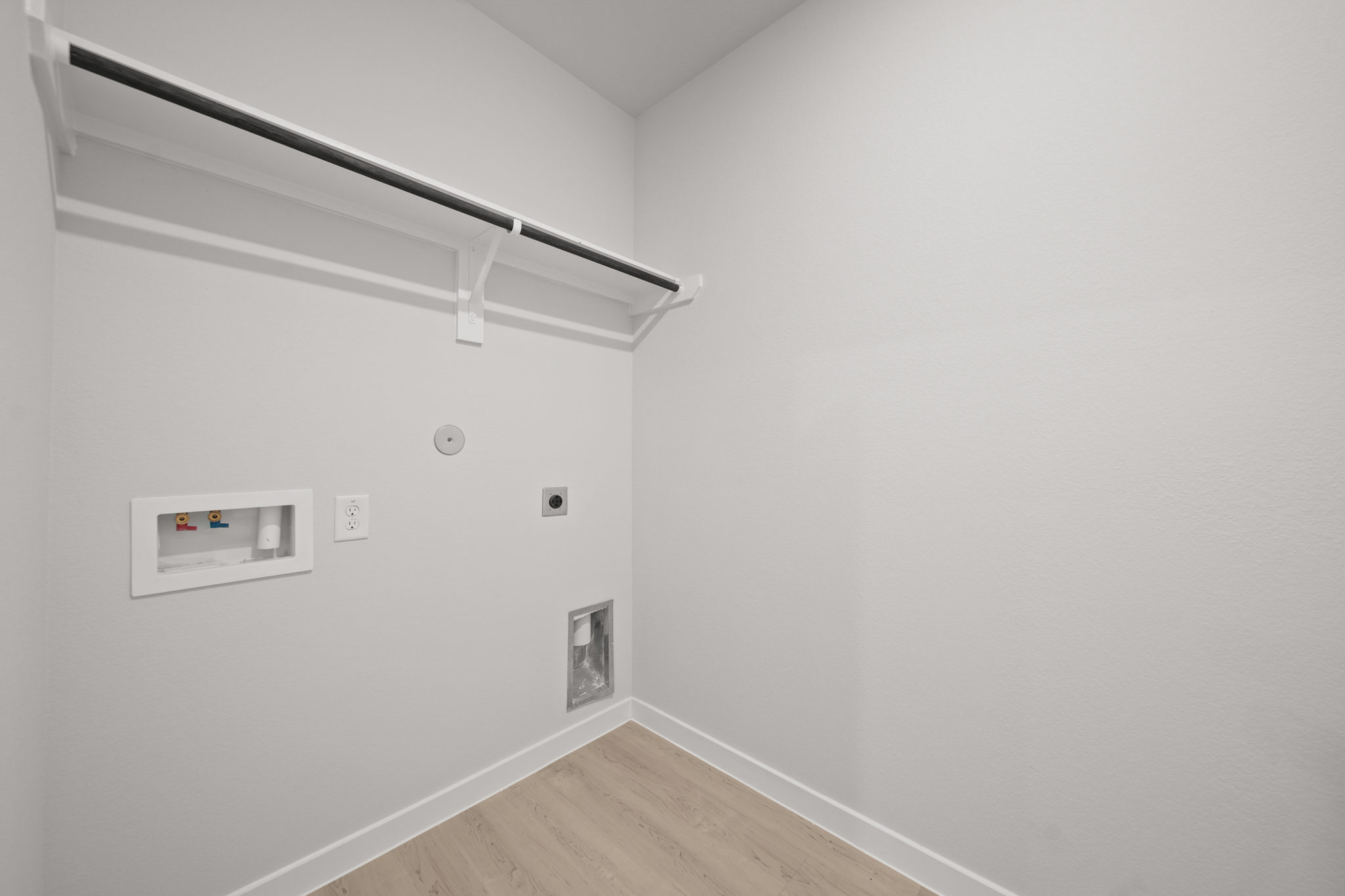 A white wall with a wood floor and a wood floor.