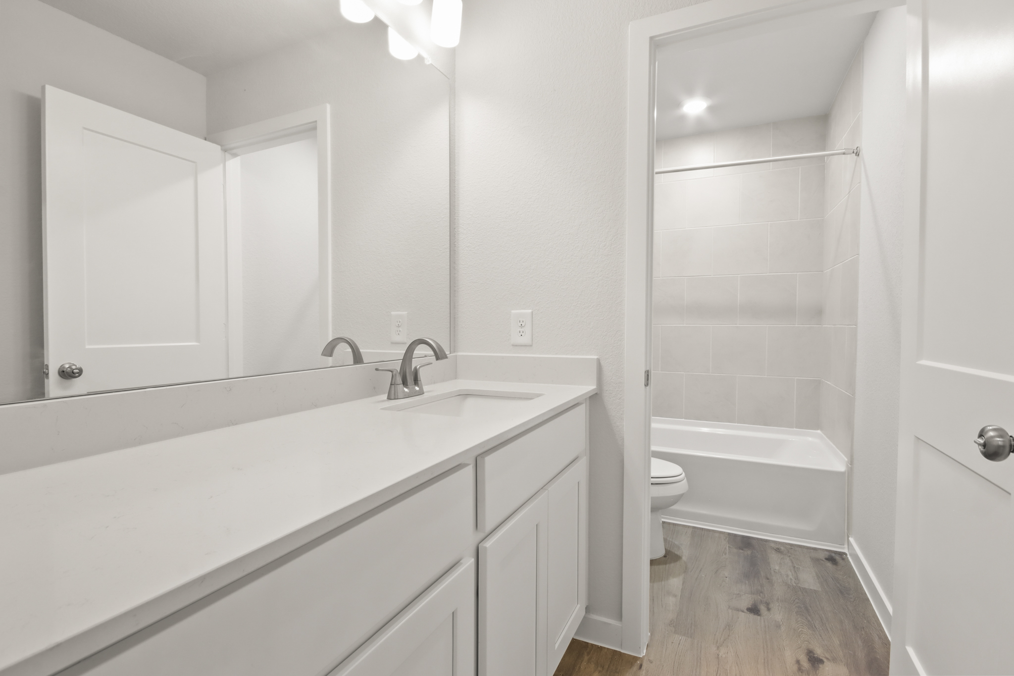 A bathroom with a tub sink and toilet.