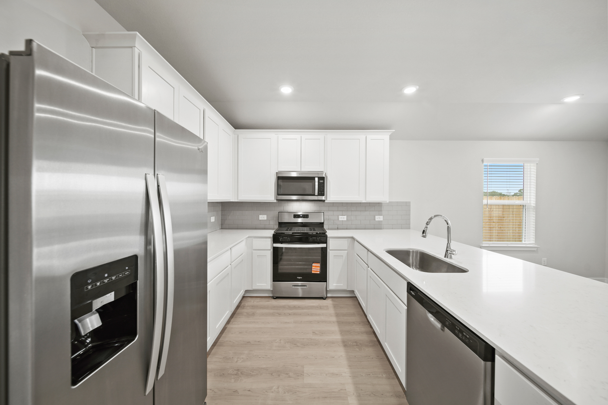 A kitchen with white cabinets.