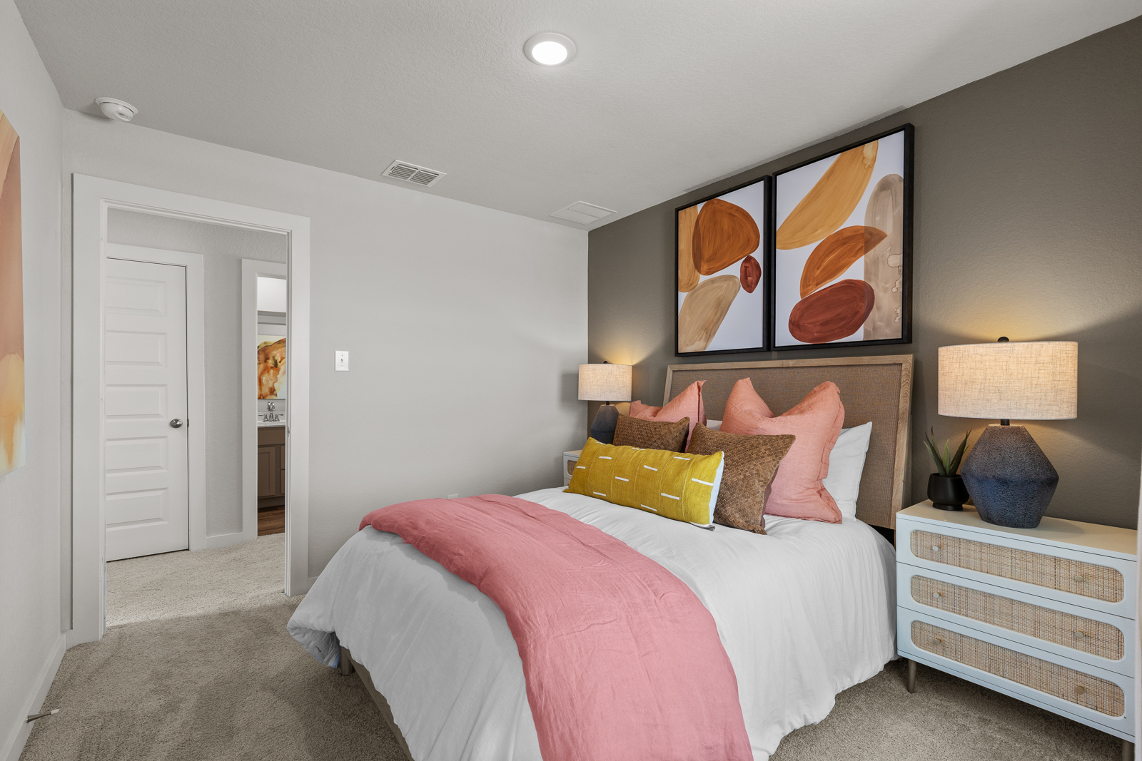 A bedroom with a pink bed.