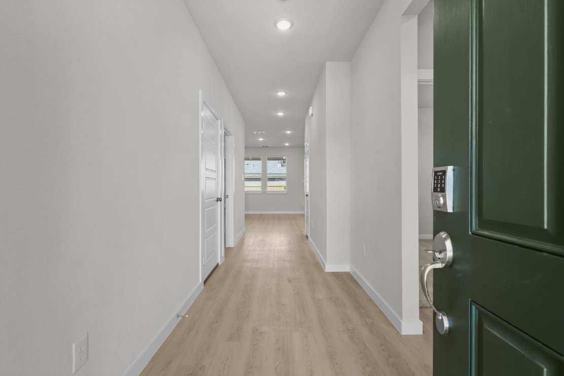 A hallway with green doors.