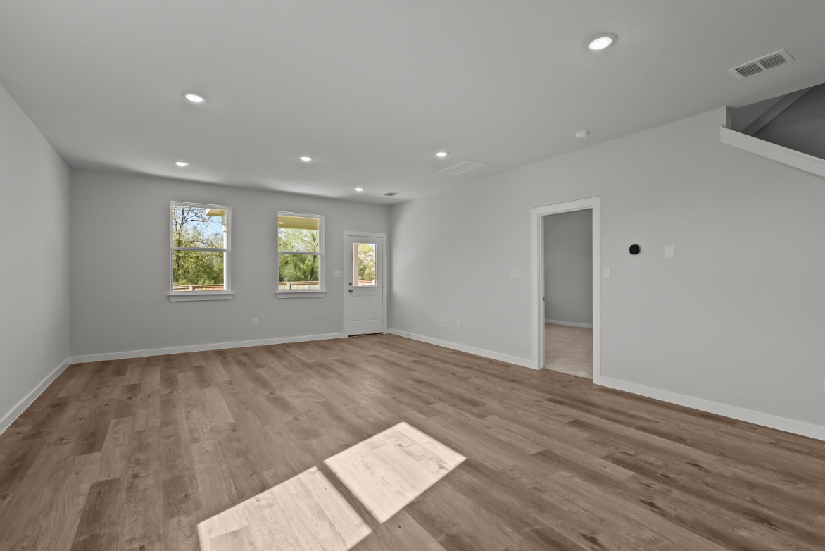 A room with a wood floor and windows.