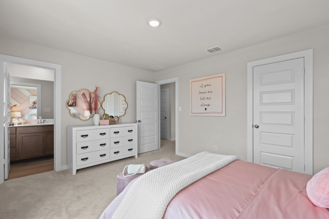 A bedroom with a bed and dresser.