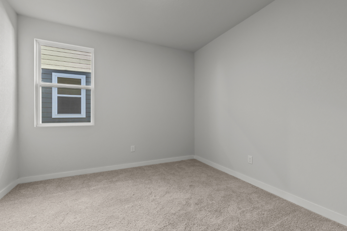A room with a window and a carpet.