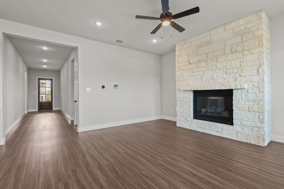 A room with a fireplace and a wood floor.