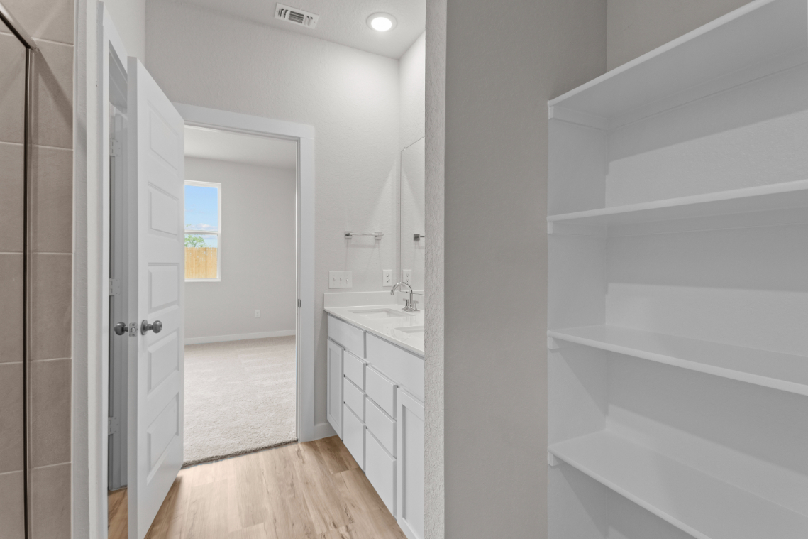 A bathroom with white cabinets.