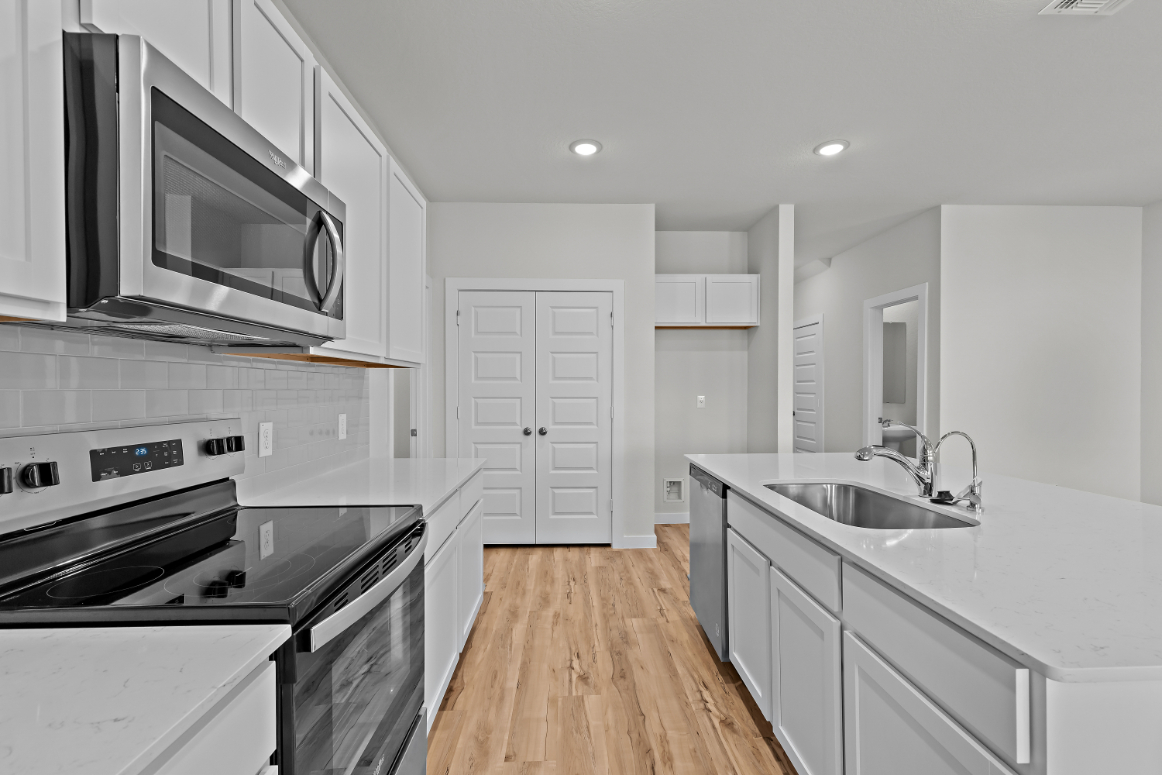 A kitchen with white cabinets.