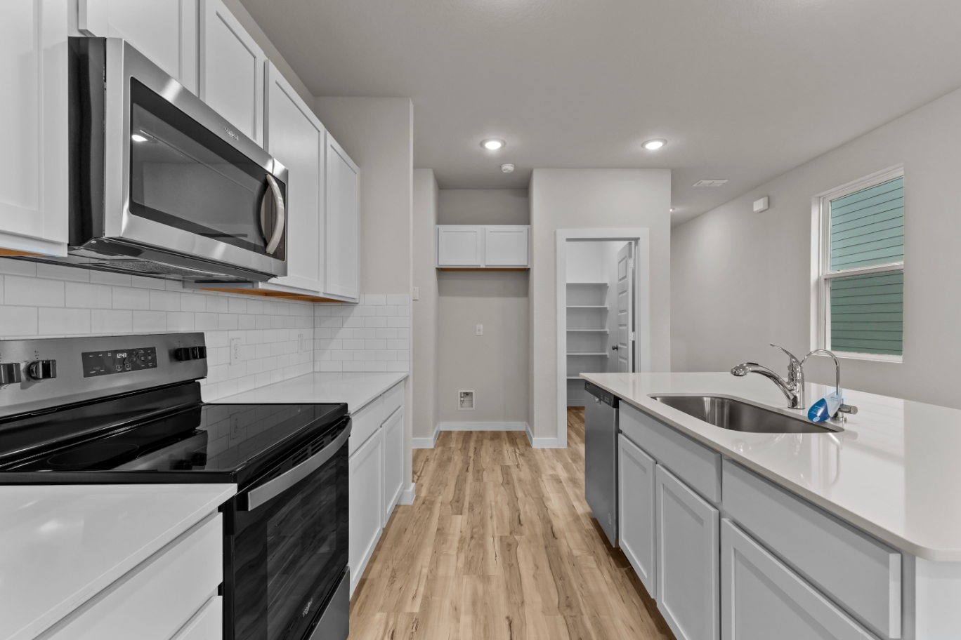 A kitchen with white cabinets.