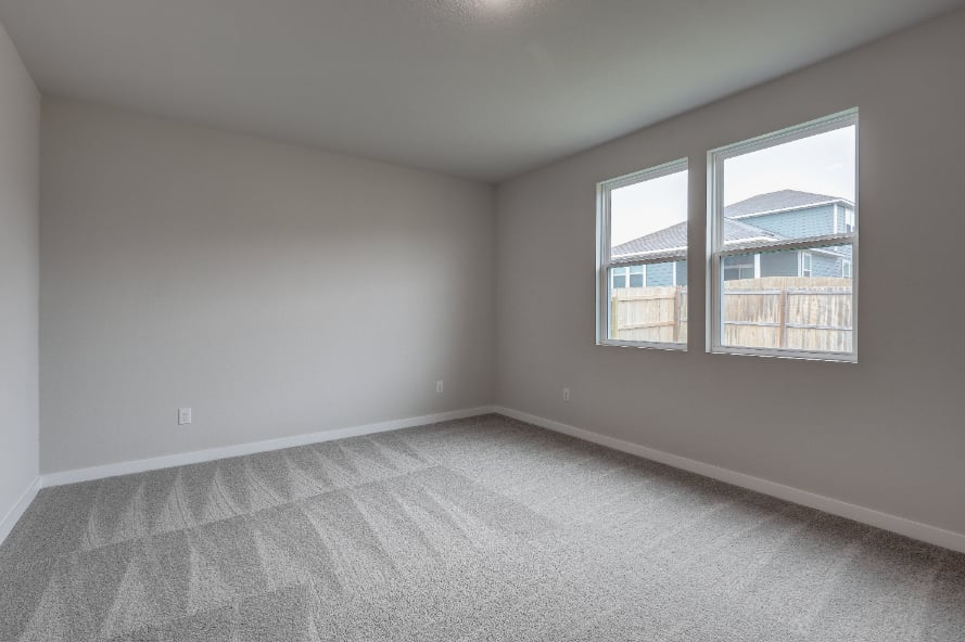 A room with a window and a carpet.