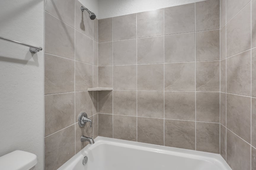 A bathroom with a bathtub and shower.