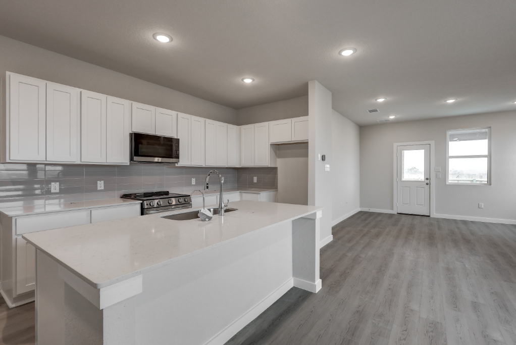 A kitchen with white cabinets.