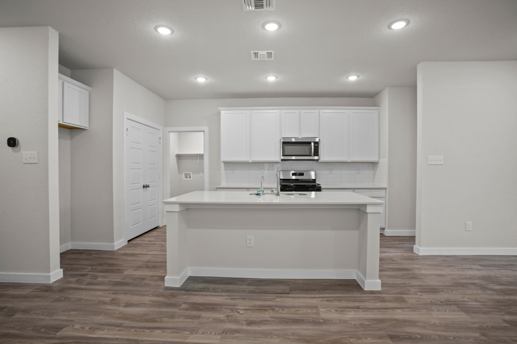 A kitchen with white cabinets.