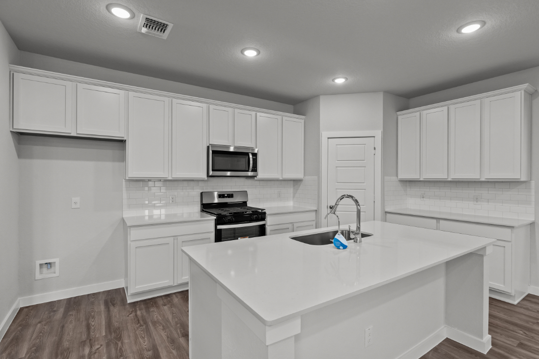 A kitchen with white cabinets.