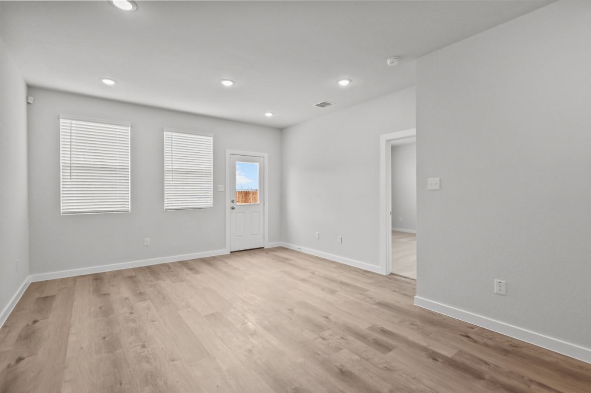 A room with white walls and wood floors.