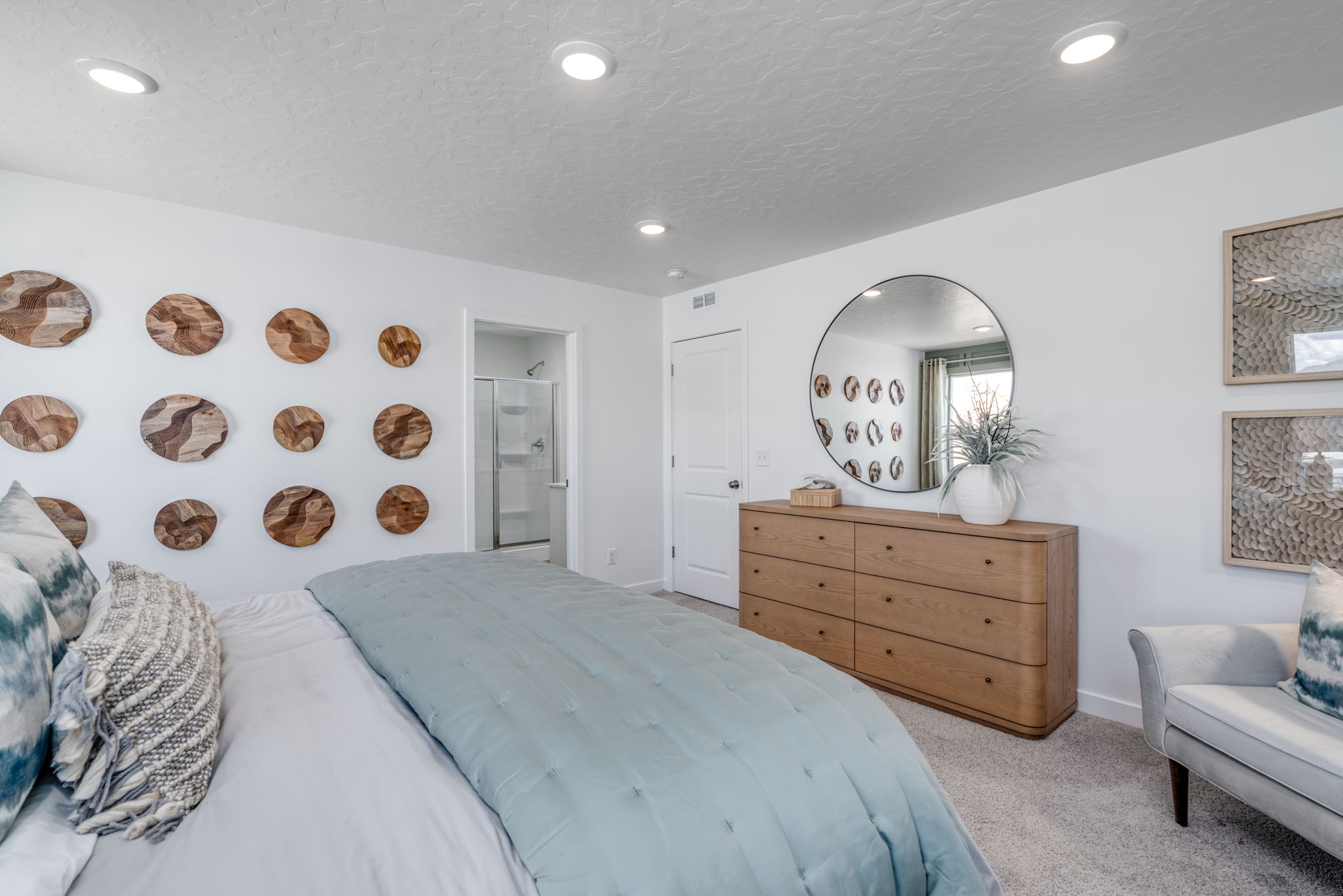 A bedroom with a bed and a mirror.