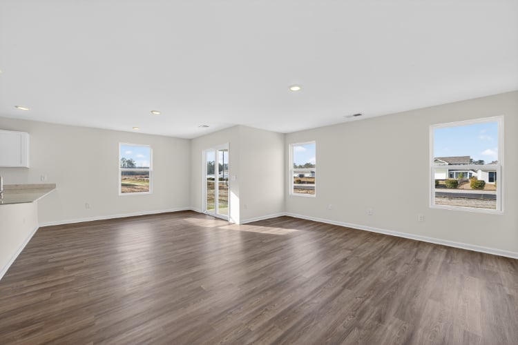 A large empty room with a wood floor and a large window.