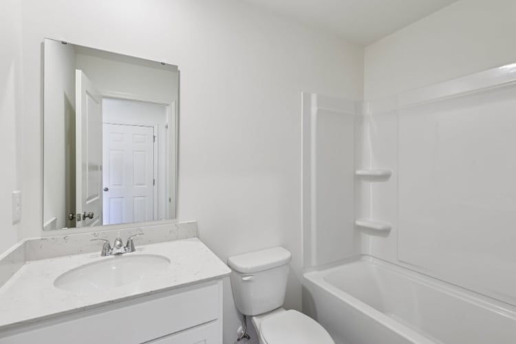 A bathroom with a sink toilet and bathtub.