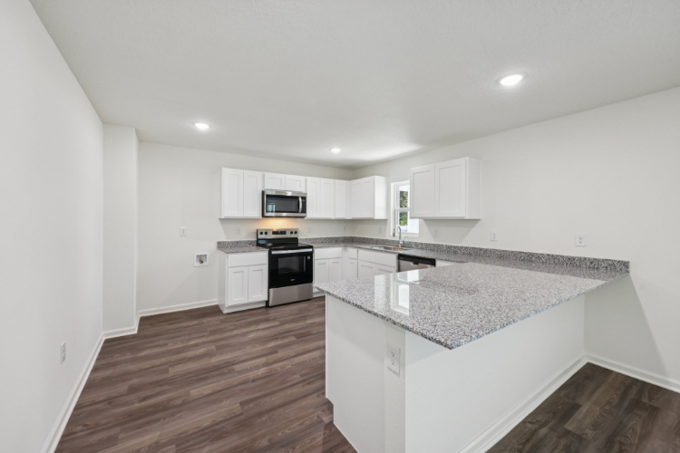 A kitchen with white cabinets.
