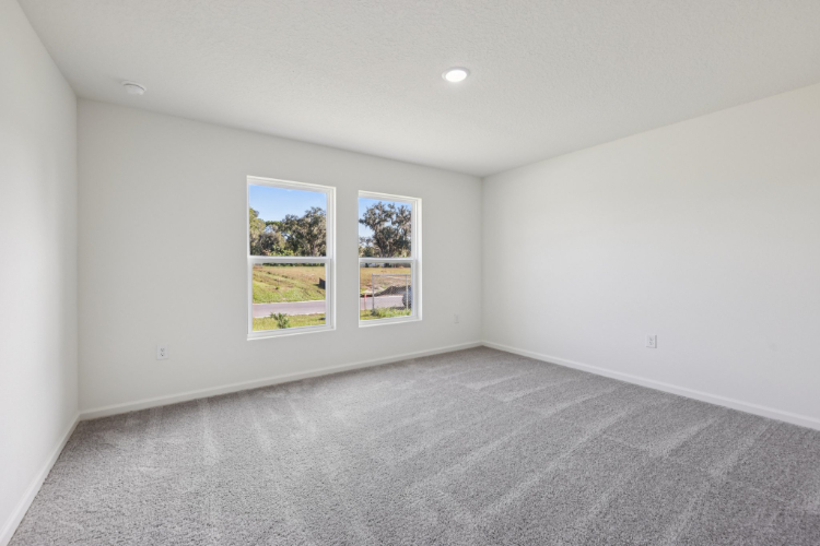 A room with a window and a carpet.