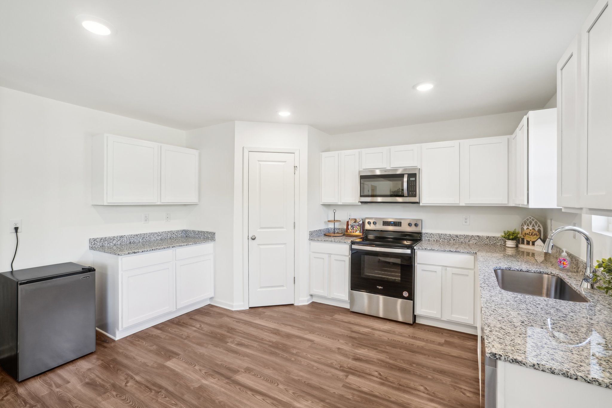 A kitchen with white cabinets.