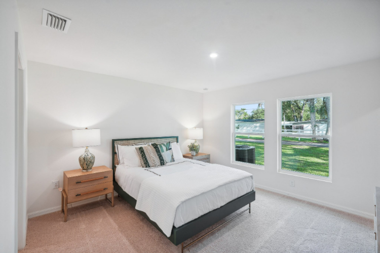 A bedroom with a large window.