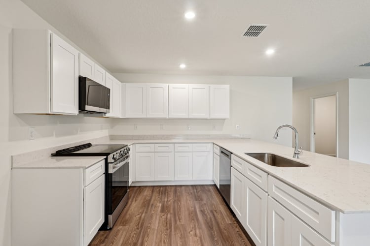 A kitchen with white cabinets.