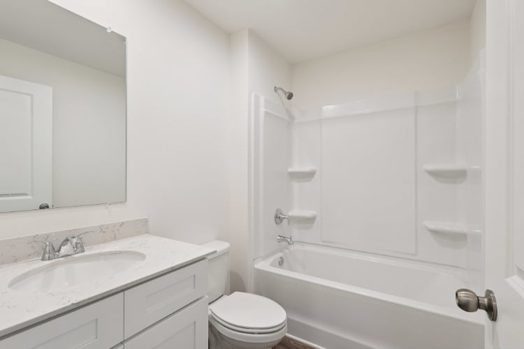 A bathroom with a tub sink and toilet.